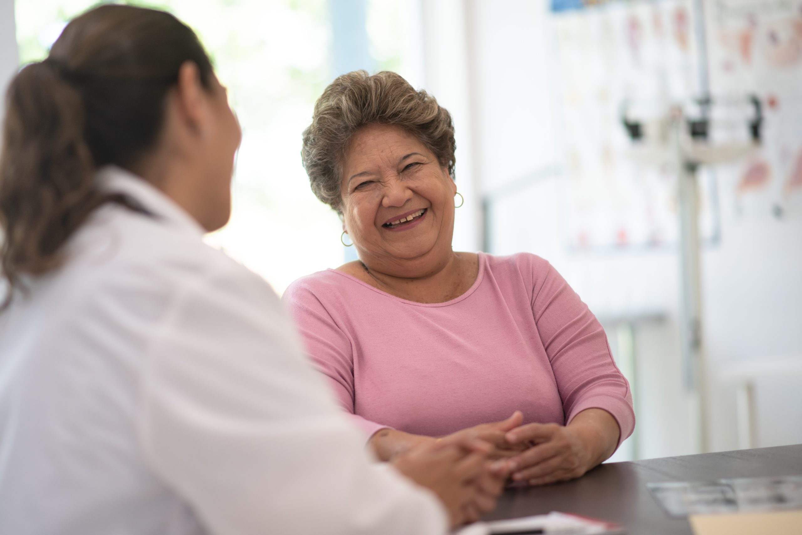 A woman is consulting with a doctor in a medical office, discussing her health concerns.